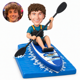 custom bobblehead figure male kayaker raising a double-bladed paddle in a touring kayak