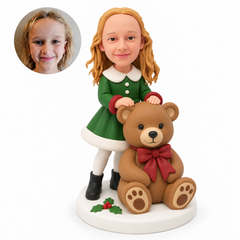 custom bobblehead figure girl in a festive coat dress standing behind a large seated teddy bear with both hands resting on its head
