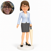 custom bobblehead figure female businesswoman holding a closed umbrella at her left side with her right arm lowered