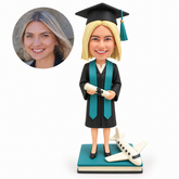 custom bobblehead figure female graduate holding a diploma beside a model passenger airplane