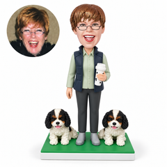 custom bobblehead figure woman holding a travel cup in her left hand beside two small sculpted dogs