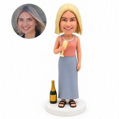 custom bobblehead figure woman holding a champagne flute in her right hand with her left arm lowered beside a fixed champagne bottle