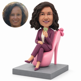 Custom bobblehead woman seated on a pink giant high heel shoe chair holding banknotes