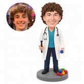 custom bobblehead figure male doctor holding an examination tool and blue ball beside colorful toy props