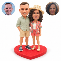 Casual bobblehead couple, man left with hand in pocket and arm around woman on heart base