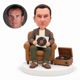 custom bobblehead figure man seated beside a vinyl record player