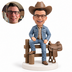 custom bobblehead figure cowboy seated on a wooden fence beside a saddle