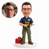 custom bobblehead figure mechanic holding a drill with both hands beside a toolbox