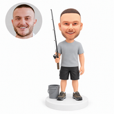custom bobblehead figure fisherman holding a rod beside a bucket