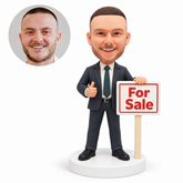 custom bobblehead figure male real estate agent beside a for sale sign giving a thumbs up