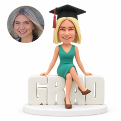 custom bobblehead figure female graduate seated on grad letters with crossed legs - custom polymer clay bobblehead figure