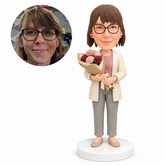 custom bobblehead figure woman in a cardigan holding a bouquet of carnations
