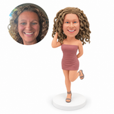 custom bobblehead figure woman in a strapless mini dress lifting one leg with one hand beside her hair