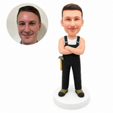 custom bobblehead figure worker in black overalls crossing his arms with a hammer at his hip