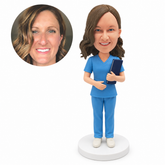 custom bobblehead figure female nurse in scrubs holding a folder against her chest