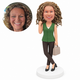 custom bobblehead figure woman in a sleeveless blouse holding a handbag with crossed legs and one fist raised