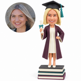 custom bobblehead figure female graduate holding a diploma on stacked books