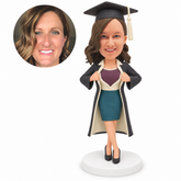 custom bobblehead figure female graduate pulling open her gown to reveal a shield-shaped shirt panel