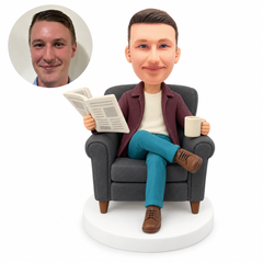 custom bobblehead figure man reading a newspaper with a mug and crossed legs in an armchair