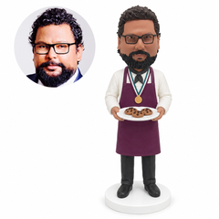 custom bobblehead figure chef wearing a medal and holding a plate of cookies