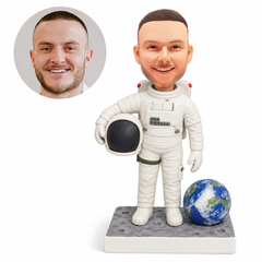 custom bobblehead figure male astronaut holding a helmet beside an Earth globe