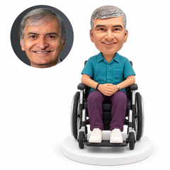 custom bobblehead figure man in a casual shirt seated in a wheelchair with hands clasped in his lap