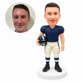 custom bobblehead figure male football player holding helmet with opposite arm down; original own-site sculpted polymer-clay head and matching human photo.