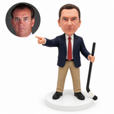 custom bobblehead figure male hockey coach in a suit pointing sideways and holding a stick