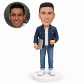 custom bobblehead figure male software engineer carrying a closed laptop with an empty hand bent at his waist