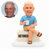custom bobblehead figure retired man seated cross-legged on a block with a mug