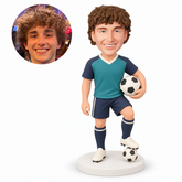 custom bobblehead figure male soccer player holding a ball with one foot on a smaller ball
