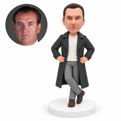 custom bobblehead figure man in a trench coat resting both hands on his hips with crossed ankles MGA-AC1255