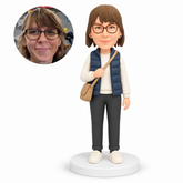 custom bobblehead figure woman in a quilted vest holding a crossbody bag strap MGA-AC1272