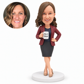 custom bobblehead figure woman in a skirt suit holding a mug with one hand on her hip and crossed ankles MGA-AC1286