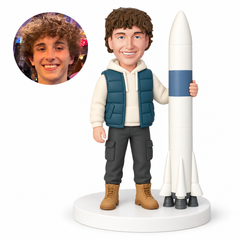 custom bobblehead figure man in a hooded vest standing beside and holding a tall rocket MGA-AC1308