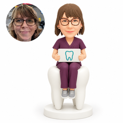 custom bobblehead figure female dentist sitting on a giant tooth and holding a sign