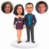 custom bobblehead figures couple holding hands with the woman in a cropped jacket and short skirt and the man keeping one hand in his pocket