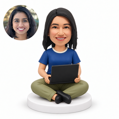 custom bobblehead figure woman sitting cross-legged directly on a round base holding an open laptop on her lap