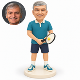 custom bobblehead figure man holding a paddle with both hands and a ball resting on its face