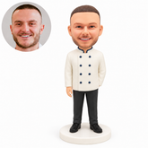 Custom clay male cook bobblehead with right hand down and left forearm behind his chef coat