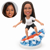 custom bobblehead figure woman surfing on a board over sculpted waves