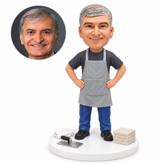 custom bobblehead figure tiler in a long work apron with both hands on his hips beside tiles