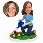 custom bobblehead figure woman kneeling to water flowers with a watering can