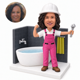 custom bobblehead figure female plumber raising a wrench beside a bathtub and tiled wall