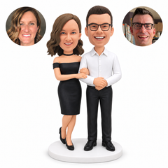custom bobblehead figures couple linking arms with a man in a white shirt and a woman in an off-shoulder dress