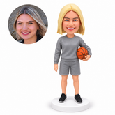 custom bobblehead figure female basketball coach in a sweatshirt and shorts holding a ball at her hip