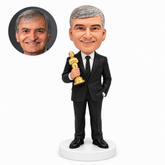 custom bobblehead figure man in a suit holding a gold award statuette