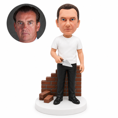custom bobblehead figure male mason holding a trowel beside a brick wall