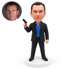 custom bobblehead figure man in a formal suit holding a miniature prop pistol