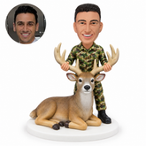 custom bobblehead figure man in camouflage standing behind a reclining deer